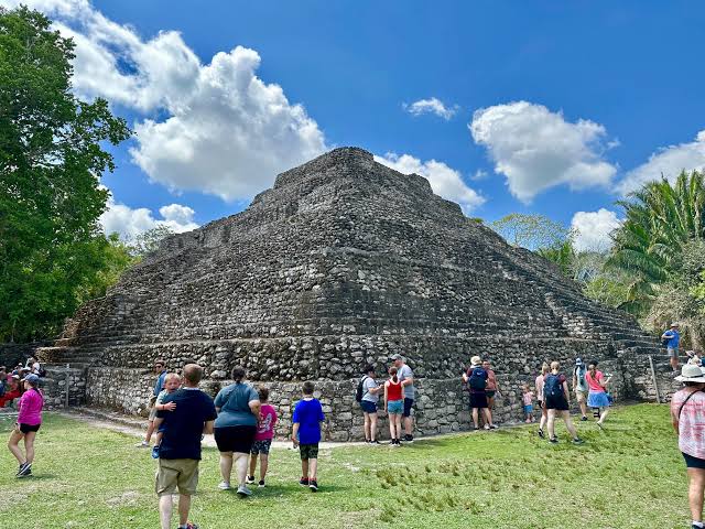 Private bilingual guide explaining Chacchoben Mayan history to tour group